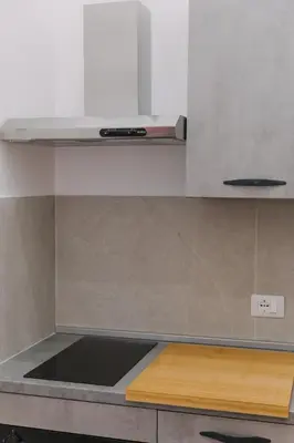 a kitchen with white cabinets and a wooden counter top at Serenello Home in Palermo