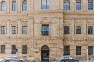 two cars parked in front of a stone building at Serenello Home in Palermo