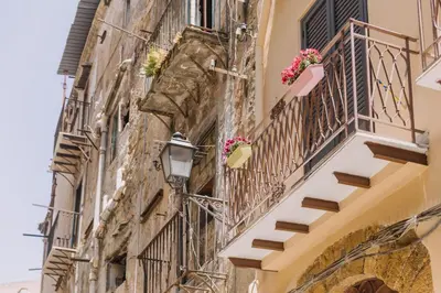 an old building with balconies and a street at Serenello Home in Palermo