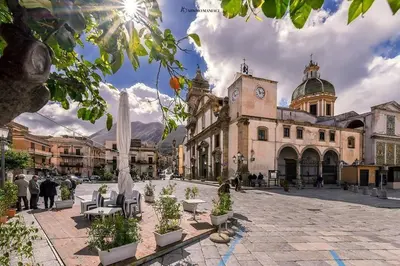 a town square with a building with a clock tower at Casa Vacanza Dante 17 Carini in Carini