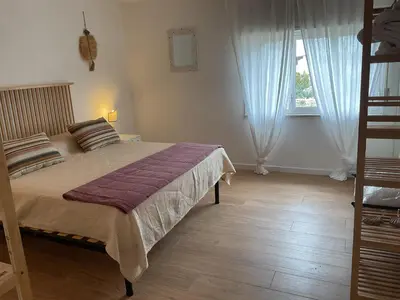 a bedroom with a large bed and a window at villa naumachos in San Vito lo Capo