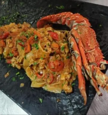 a plate of food with shrimp and vegetables on a table at Mondello Sea House in Palermo