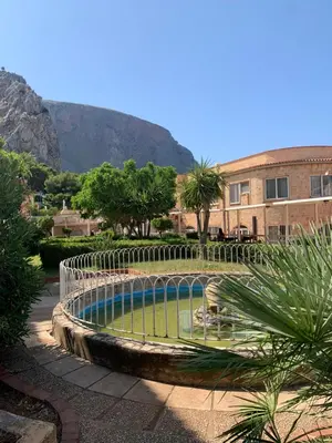 a pool in the middle of a garden with a building at Mondello Sea House in Palermo