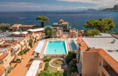 a resort with a swimming pool and the ocean at Mondello Sea House in Palermo