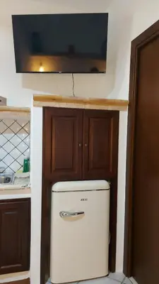 a kitchen with a refrigerator and a tv on the wall at Casa dei normanni in Palermo