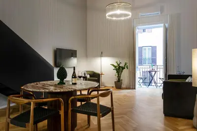 a living room with a round table and chairs at Dimora Ai Leoni, Suite & Apartments in Palermo