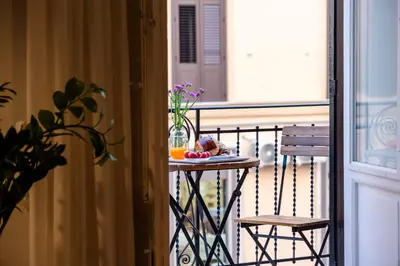 a table with a plate of food on a balcony at Dimora Ai Leoni, Suite & Apartments in Palermo