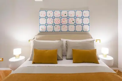 a bedroom with a large bed with yellow pillows at Dimora Ai Leoni, Suite & Apartments in Palermo