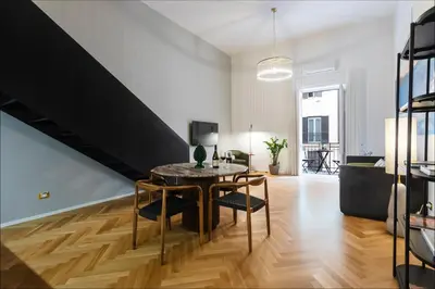a living room with a table and chairs and a staircase at Dimora Ai Leoni, Suite & Apartments in Palermo