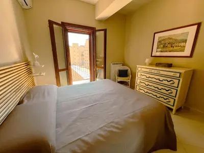 a bedroom with a bed and a dresser and a window at Belmonte 18 in Palermo