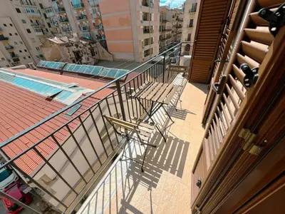 a balcony with two chairs on a building at Belmonte 18 in Palermo
