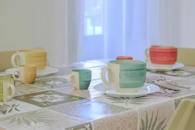 a table topped with cups and plates on a table at CELSO E SAITTA per SAITTA HOLIDAYS in Palermo