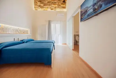 a bedroom with a bed with a blue blanket at Casa Ru Vecchio Re in Palermo