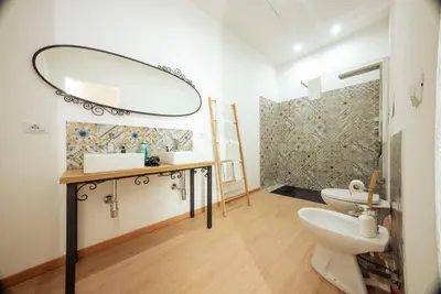 a bathroom with a sink and a toilet and a mirror at Casa Ru Vecchio Re in Palermo