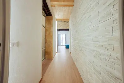 a hallway with white walls and a stone wall at Casa Ru Vecchio Re in Palermo