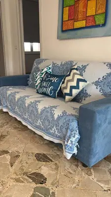 a blue couch with pillows on it in a living room at Mondello House29 in Palermo