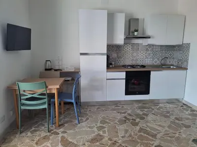 a kitchen with a table and some chairs and a counter at Mondello House29 in Palermo