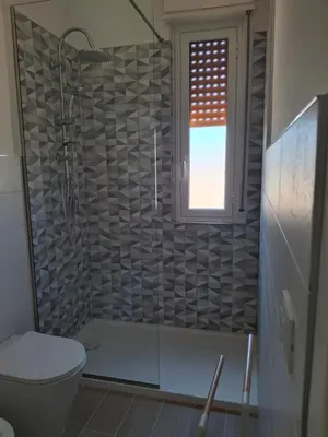 a bathroom with a shower with a toilet and a window at Mondello House29 in Palermo