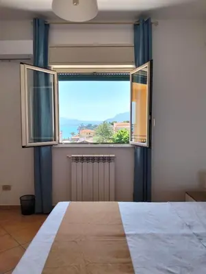 a bedroom with a large window and a radiator at Il mare negli occhi in Porticello