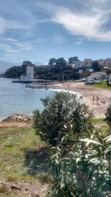 a beach with people on the sand and the water at Il mare negli occhi in Porticello
