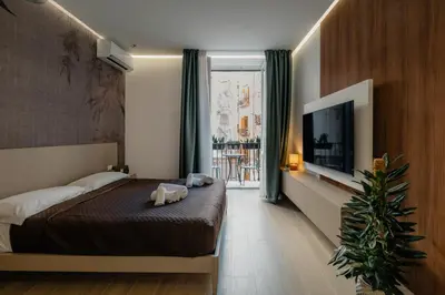 a hotel room with a bed and a television at Vincis Home in Palermo