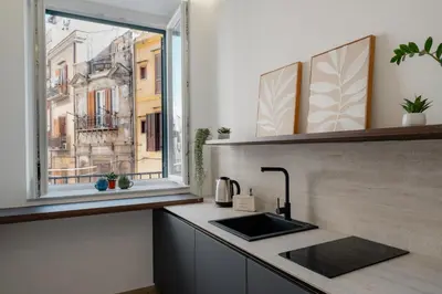 a kitchen with a sink and a window at Vincis Home in Palermo