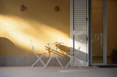 a table and two chairs sitting next to a wall at Villa Azzurra in Scopello