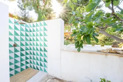 a white fence with a green and white tile wall at Villa Azzurra in Scopello