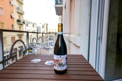 a bottle of wine sitting on a table with wine glasses at House Via Napoli in Palermo