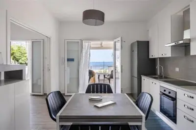 a kitchen with a table and chairs in a kitchen at la villetta sul mare in Palermo