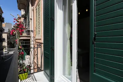 a green door to a building with a balcony at La Casa Del Vecchio Borgo in Palermo