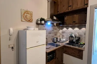 a small kitchen with a refrigerator and a sink at La Casa Del Vecchio Borgo in Palermo