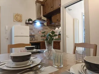 a dining room table with a vase of flowers on it at La Casa Del Vecchio Borgo in Palermo