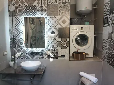 a bathroom with a sink and a washing machine at La Casa Del Vecchio Borgo in Palermo