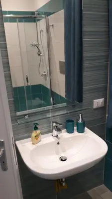 a bathroom sink with a mirror and a shower at Casa vacanza galatea San vito lo capo in San Vito lo Capo