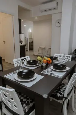a dining room table with black plates and wine glasses at House Paradise- House Arena in Porticello