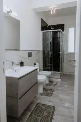 a bathroom with a sink and a shower and a toilet at House Paradise- House Arena in Porticello