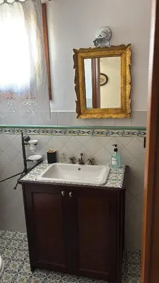 a bathroom with a sink and a mirror at Casa Vacanze Mazzini, amazing Rooftop! in Termini Imerese