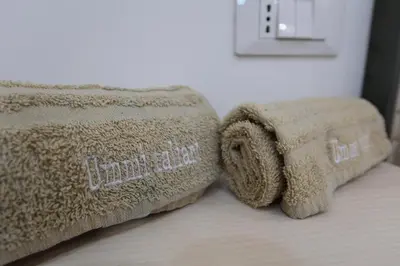 a bed with a comforter and a towel at Ummi Taliari in Terrasini