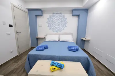 a bedroom with a blue bed with two towels on it at Ummi Taliari in Terrasini