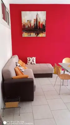 a living room with a couch and a red wall at Nicitra in Isola delle Femmine