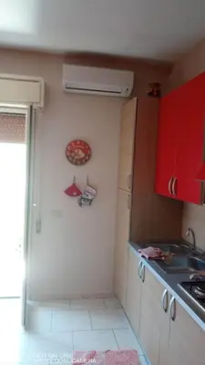 a kitchen with red cabinets and a sink at Nicitra in Isola delle Femmine