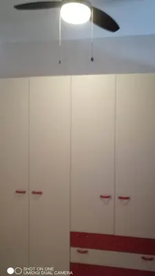 a closet with white cabinets and a ceiling fan at Nicitra in Isola delle Femmine
