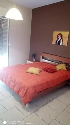 a bedroom with a large bed with a red blanket at Nicitra in Isola delle Femmine