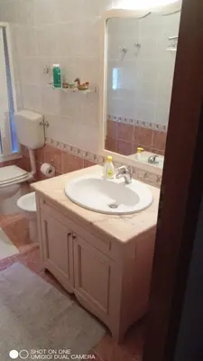 a bathroom with a sink and a toilet and a mirror at Nicitra in Isola delle Femmine