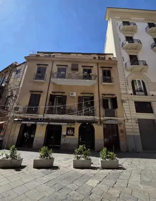 a large building with potted plants in front of it at A Casa di Iside in Palermo