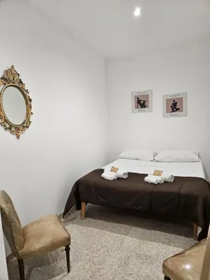 a bedroom with a bed and a mirror and a chair at La Corte Di San Basilio palermo in Palermo