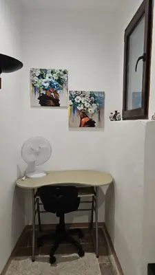 a desk with a chair and three paintings on the wall at La Corte Di San Basilio palermo in Palermo