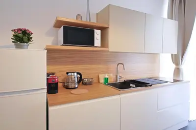 a kitchen with white cabinets and a sink and a microwave at Suites Santa Cecilia in Palermo