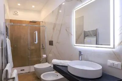 a bathroom with a sink and a toilet and a shower at Suites Santa Cecilia in Palermo
